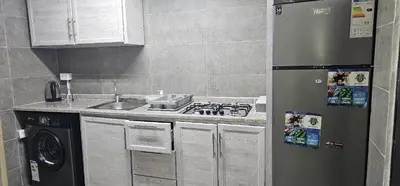 a kitchen with a stainless steel refrigerator and a sink at ستوديو مستقل داخل فيلا in Amman