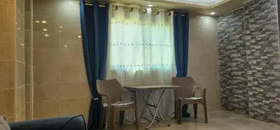 a room with two chairs and a table and a curtain at ستوديو مستقل داخل فيلا in Amman