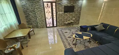 a living room with a blue couch and a table at ستوديو مستقل داخل فيلا in Amman