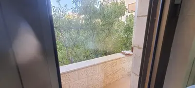 an open window with a view of a garden at Furniture apartment for families 3 bedroom in Al Bunayyāt ash Shamālīyah