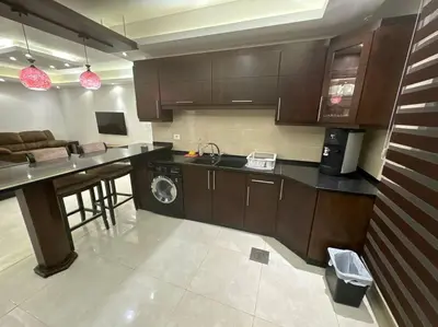 a kitchen with brown cabinets and a counter top at 2 En-suite Rooms, Central & Spacious in Amman