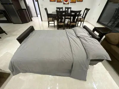 a bed in a room with a table and chairs at 2 En-suite Rooms, Central & Spacious in Amman