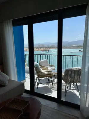 a room with a balcony with a view of the water at Aladdin Chalet 13 in Aqaba