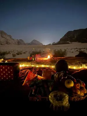 a table with a fire in the desert at night at Camp star road safari in Wadi Rum