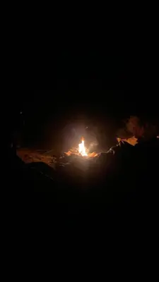 a fire is burning in the dark at night at Camp star road safari in Wadi Rum