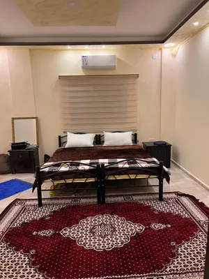 a bedroom with a bed and a red rug at Indiana Jones Home Stay in Petra