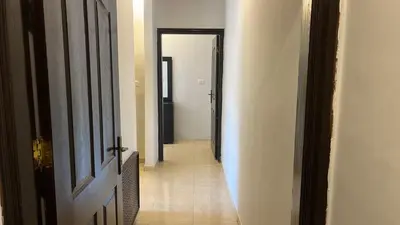 an empty hallway with an open door and a hallwayngthngthngthngthngthngth at Izz AlDin Tamimi St شقة مفروش سوبر ديلوكس الجبيهة in Ţāb Kirā‘