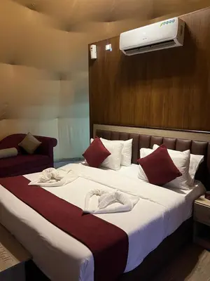 a hotel room with a bed with a air conditioner at Bright Stars Camp in Disah