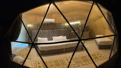 a view of a bedroom through a glass window at Bright Stars Camp in Disah