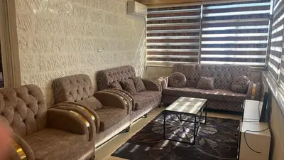 a living room with two couches and a table at الروف سوبر ديلوكس 2 غرف نوم صالة جلوس و طعام مكيفة للإيجار in Amman
