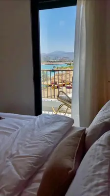 a bedroom with a bed and a view of a balcony at Aladdin Chalet 15 in Aqaba