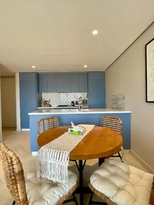 a kitchen with a wooden table and chairs at Aladdin Chalet 15 in Aqaba