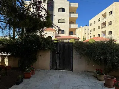 a black gate in a courtyard with a building at Ayyash in Amman
