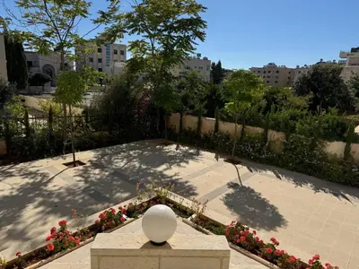 a view of a park with flowers and a fence at Ayyash in Amman