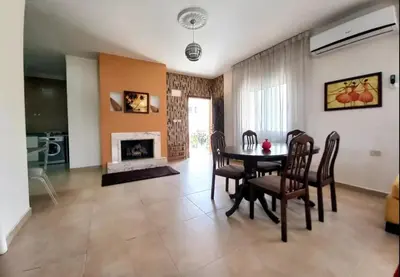 a dining room with a table and a fireplace at Ayyash in Amman