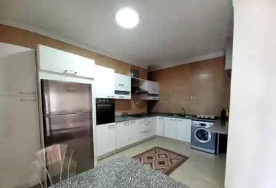 a kitchen with white cabinets and a stainless steel refrigerator at Ayyash in Amman