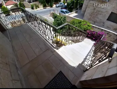 a metal railing on a staircase with flowers at Ayyash in Amman