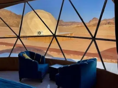 a room with two blue chairs and a view of a desert at RUM MARS lUXURY CAMP in Wadi Rum