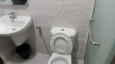 a bathroom with a white toilet and a sink at Elegant Apartment in Amman