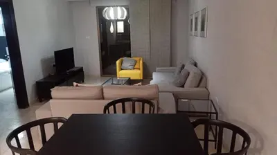 a living room with a couch and a table and chairs at Elegant Apartment in Amman