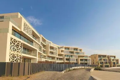 a large building with a fence in front of it at Modern Apartment In Ayla in Aqaba