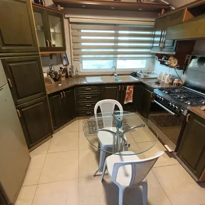 a small kitchen with a glass table and chairs at Said in Amman