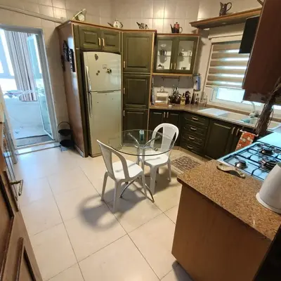 a kitchen with a glass table and a refrigerator at Said in Amman