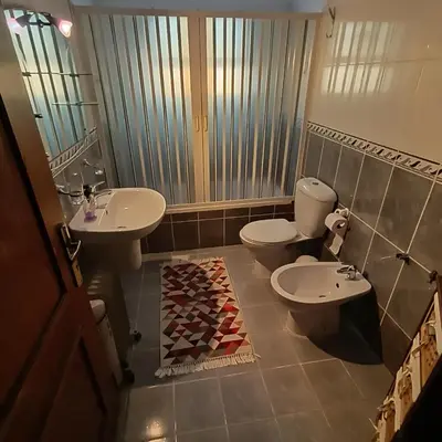 a bathroom with two toilets and a sink and a mirror at Said in Amman