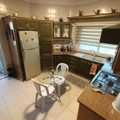 a kitchen with a refrigerator and a table and chairs at Said in Amman