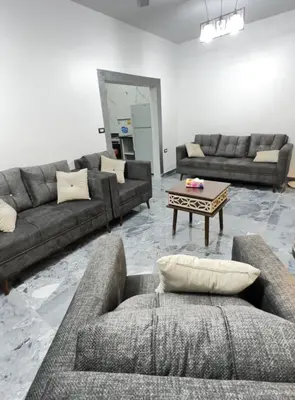 a living room with couches and a coffee table at مزرعة ريفان in Dawqarah