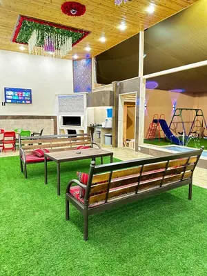 a playground with benches and a ping pong table at مزرعة ريفان in Dawqarah