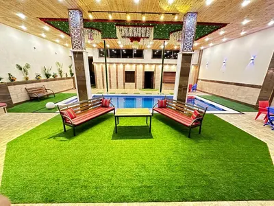 a pool with two benches and a table in a building at مزرعة ريفان in Dawqarah