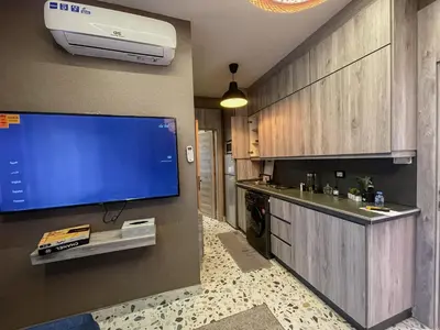 a kitchen with a large flat screen tv on the wall at Hawari Group in Amman