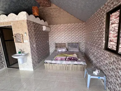 a bedroom with a bed and a sink in a room at Dream Bedouin Life Camp Wadi Rum in Disah