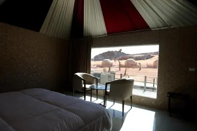 a bedroom with a bed and a table and chairs at Eagle Rum Camp in Disah