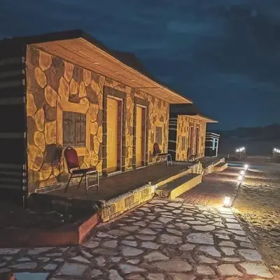 a stone house with a chair on a patio at night at Mountain star in Disah