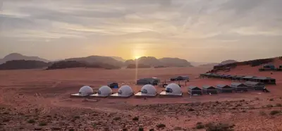 a group of domes in the desert with the sunset at Mountain star in Disah