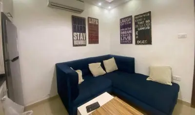 a blue couch in a living room with posters on the wall at الأردن عمان ضاحية الأمير راشد شارع مكه in Umm Uthainah