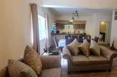 a living room with a couch and a dining room at Peppermint AL Weibdeh 1-Bed Cozy Apartment in Ash Shumaysānī