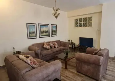 a living room with two couches and a tv at Peppermint AL Weibdeh 1-Bed Cozy Apartment in Ash Shumaysānī