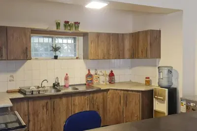 a kitchen with wooden cabinets and a sink and a counter top at Peppermint AL Weibdeh 1-Bed Cozy Apartment in Ash Shumaysānī