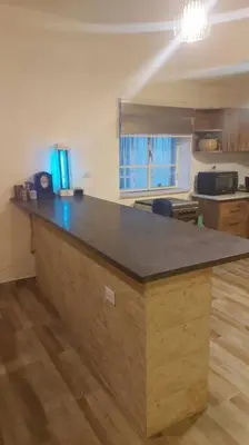 a kitchen with a wooden counter top in a room at Peppermint AL Weibdeh 1-Bed Cozy Apartment in Ash Shumaysānī