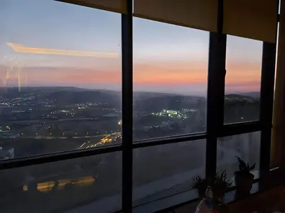 a view of a city from a window at sunset at Villa rose 3 in Khirbat Abū Ḩāmid