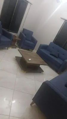 a waiting room with blue chairs and a table at أبو راشد للشقق المفروشه in Aqaba