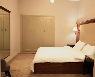 a bedroom with a large bed with white sheets at Alqalah Restotel فندق ومطعم القلعة in Kerak