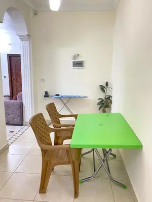 a green table and two chairs in a room at Jerash Gate in Jerash