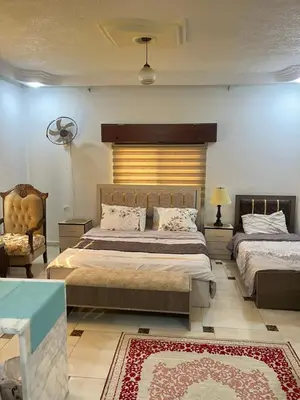a bedroom with two beds and a chair at Jerash Gate in Jerash