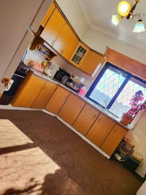 a kitchen with wooden cabinets and a large window at L goats house in Wadi Musa