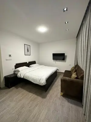 a bedroom with a large bed and a couch at central apartment for rent 16 in Umm Uthainah