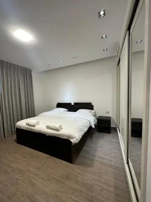 a bedroom with a bed and a large mirror at central apartment for rent 18 in Umm Uthainah